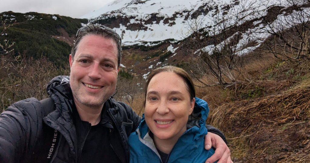 Wes and Rachele pose during a hike in the snowy mountains above Juneau, Alaska while on a cruise
